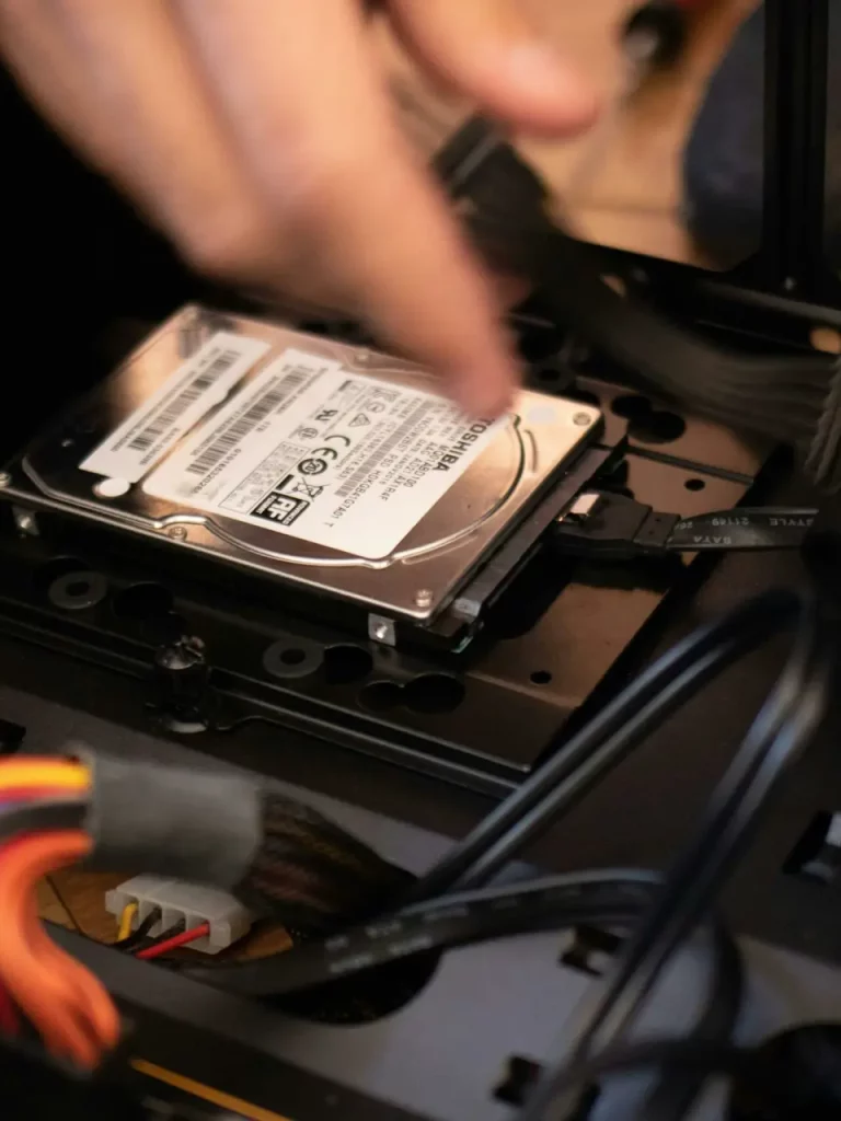 pexels-photo-2582931-2582931 Hands installing a hard drive in a computer case, emphasizing technology and connectivity.